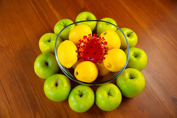 Coronavirus hiding in usual things - check cleanse and freshness of your fruits and food. One of the bunch. Apples, oranges, lemons on the kitchen's table. Pandemic, epidemic concept, disinfecting.