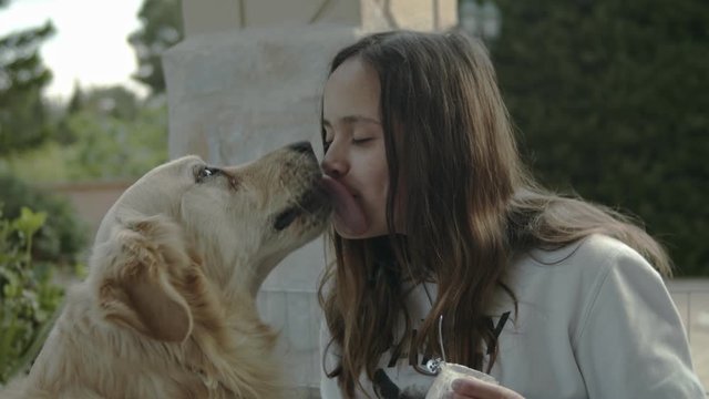 Niña adolescente jugando con perro golden retrevier