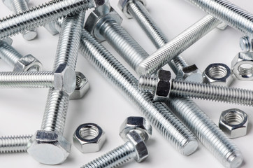 Lots of metal bolts and nuts. Tool for fixing. White background