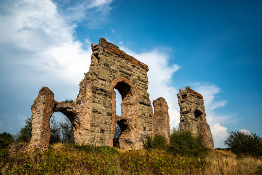 A dramatic image of the ruins of a Roman aqueduct, Italy. The Parco degli Acquedotti is an archeological which concerns the water supply system of ancient Rome. It is part of the Appian Way Park.