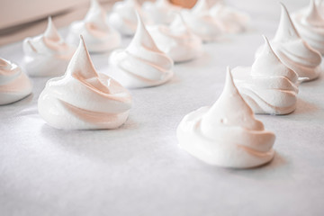 Fototapeta na wymiar Lots of homemade meringue on a baking sheet
