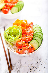 Salmon poke with avocado, cucumber, and rice on marble background , top view. Asian trendy food