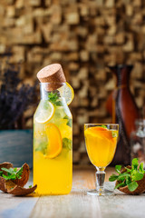 Side view on fresh cool lemon lemonade with mint on the wooden table, vertical