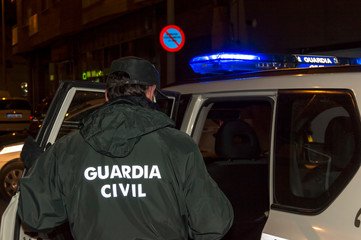 Guardia Civil enters the patrol car at a checkpoint during the Covid-19 pandemic © C&A