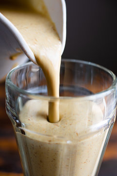 Close Up Of Seeded Banana Frappe Smoothie Being Poured Into Glass