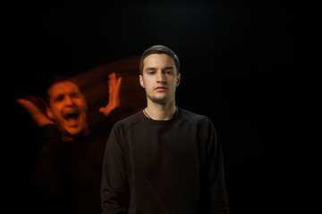 Cold outside, surprised inside. The versatility of man - opened emotions and hidden feelings. Caucasian man on black background with different faces of condition. Double exposure. Mental health.
