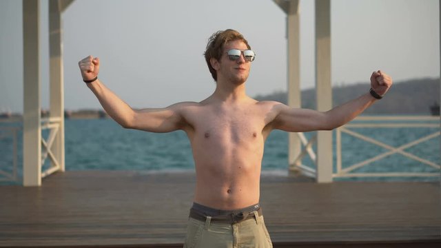 Over The Top Fitness Guy With Sunglasses Showing off and Flexing Muscles in Public