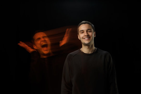 Cheerful outside, screaming inside. The versatility of man - opened emotions and hidden feelings. Caucasian man on black background with different faces of condition. Double exposure. Mental health.