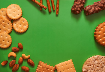 composition biscuits and almonds on a green background lay flat