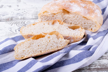 Freshly baked wheat bread cut into slices on the cotton towel