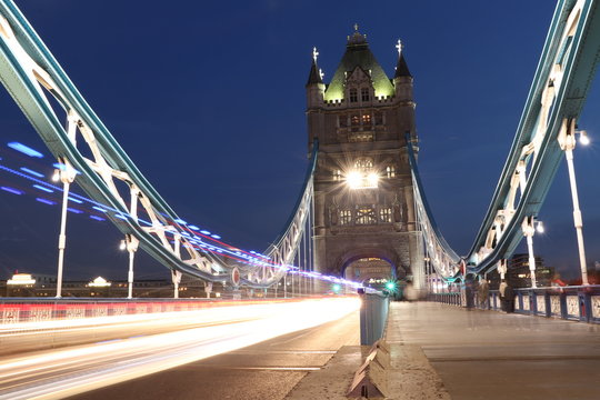 Stopping in time on Tower bridge in midnight. Work only with long exposure create picture from future. Lighted bridge with many different shadow of yellow lighting as stars on sky with comet flight