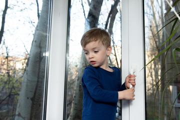 a small child is trying to open a window.