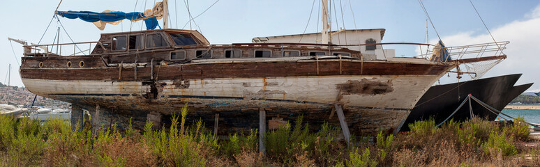 old, rusty ship abandoned on the shore.