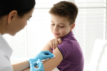 Doctor vaccinating little child in modern clinic
