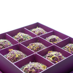 Closeup photo with focus in the center of sweets sprinkled with rose petals on an isolated background
