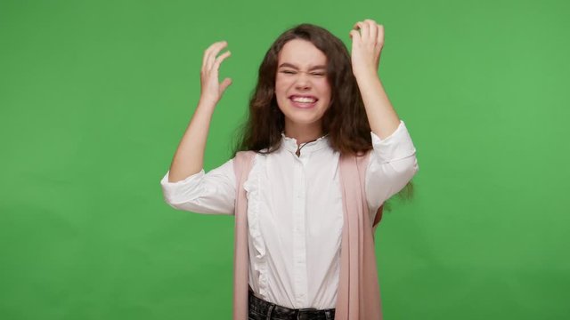 Happy impressed teenage brunette girl in white shirt looking with mouth open in pleasant surprise, shocked by news about victory, disbelief reaction. indoor studio shot isolated on green background