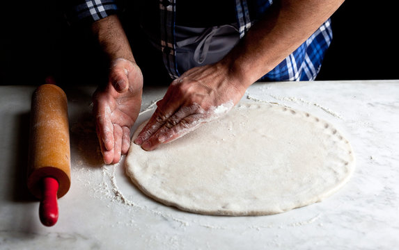 Hands kneading dough for pizza&dagger;calzone
