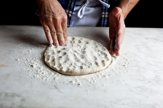 Hands kneading dough for pizza calzone