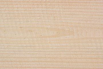 A rough wooden surface. Light yellow natural background or wallpaper. Annual rings and wood fibers close-up. Woodworking, carpentry and joinery. Macro