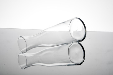 Close up of reflection of empty glass bottle on table