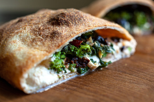 Cross section of broccoli rabe, olive and&dagger;parmesan&dagger;calzone