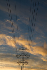 Power lines against sunset sky and clouds