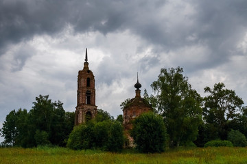 A cloudy landscape with an abandoned Church standing among trees. Ivanovo region, Russia.