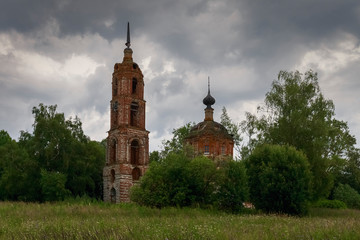 A cloudy landscape with an abandoned Church standing among trees. Ivanovo region, Russia.