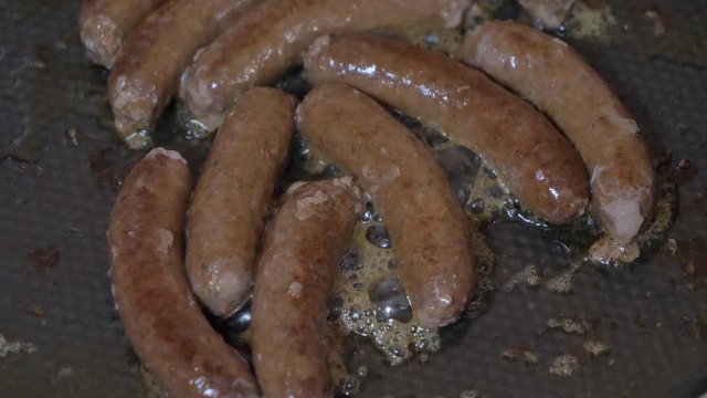 Close up shot of Grilling sausage on the grill plate, outdoors. Grilling food, bbq, barbecue, 4k