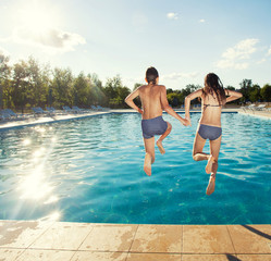 Couple jumping into pool