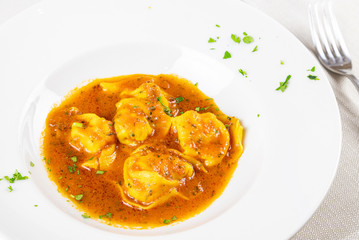 Plate of tortellini with fish sauce. Tortellini, homemade cappelletti. Menu photography.