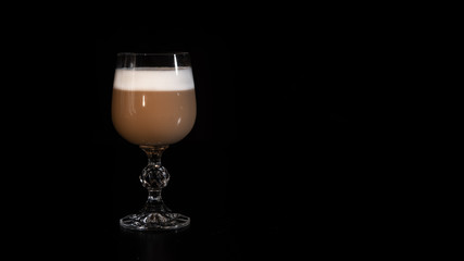 multilayer coffee or cappuccino in a glass cup on black background