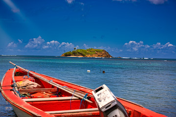 Small wooden colorful boat on clear water ocean