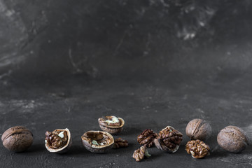 halves of the kernel of a healthy walnut without shell on a dark background, walnut Macro food photo close-up view.
