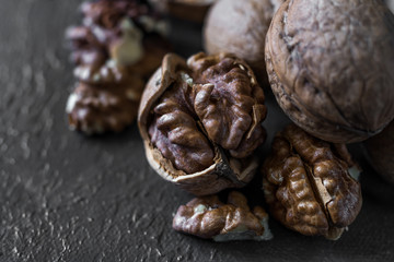 halves of the kernel of a healthy walnut without shell on a dark background, walnut Macro food photo close-up view.