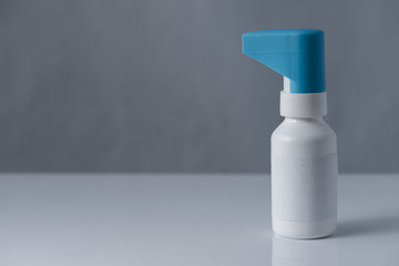 throat spray bottle. closed system with blue cap, isolated on white background