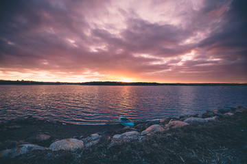 Empty Kayak is on the rocks beach during the sunset in Nova scotia Canada