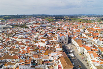 Evora drone aerial view on a sunny day with historic buildings city center and church in Alentejo,...