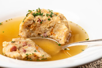 single speckknoedel in soup on wood