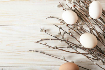 Raw white chicken eggs with willow on a white background, top view with place for text.