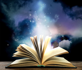 Magic light emanating from open old book on table