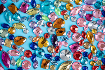 Fototapeta na wymiar colored rhinestones on a turquoise background, color texture