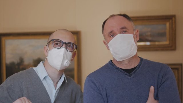 Two people in medical masks standing in the gallery look at the exhibit