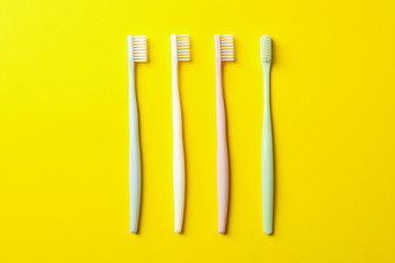 Toothbrushes on yellow background, top view. Dental care