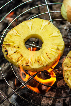 Slices of pineapple being grilled
