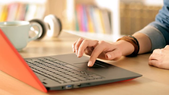 Close up of student hands e-learning browsing on laptop at home