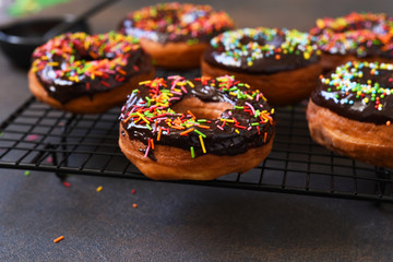American donut with chocolate and candy on a concrete background.