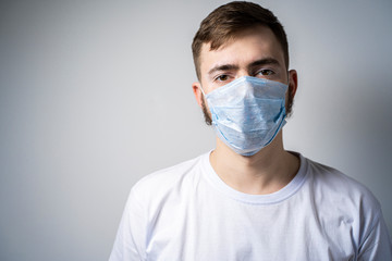 A bearded man in a medical mask looks at the camera. Self isolation