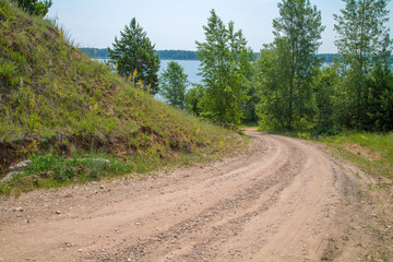 dirt road on a sunny day, descent to the river