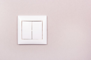 White plastic switch on gray background. White two-button switch. White plastic switch copy space
